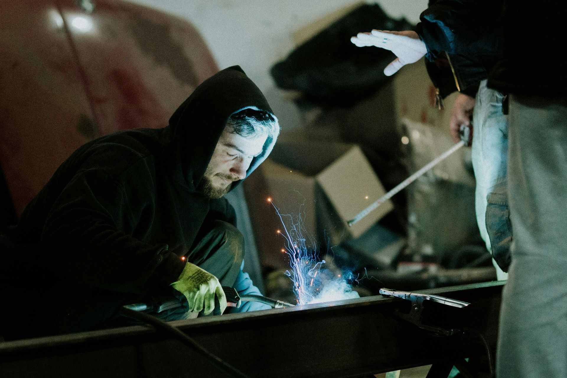 A man welding an industrial machine.