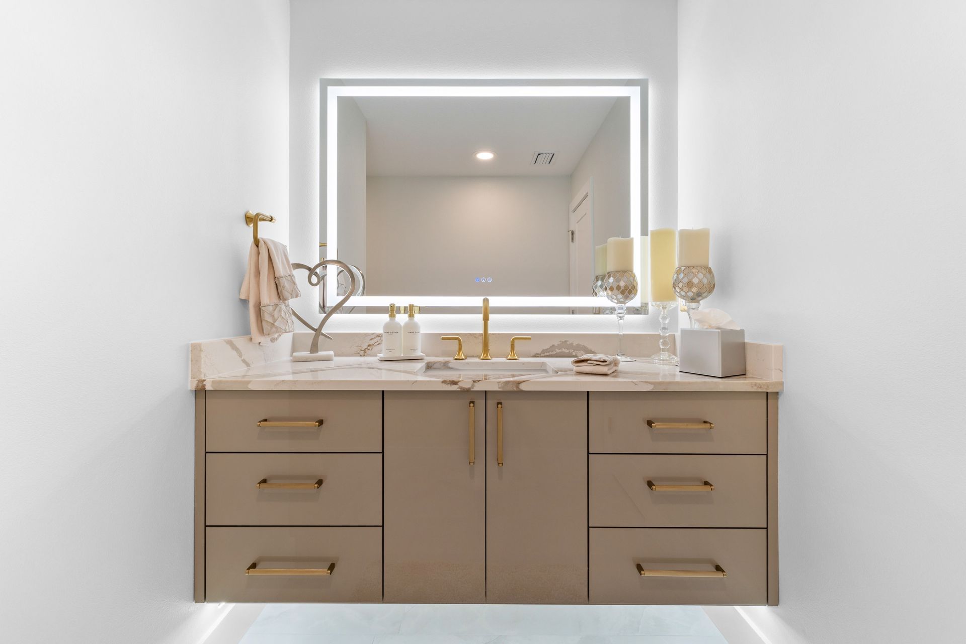 Modern bathroom vanity with double sink, large lit mirror, and beige cabinets.