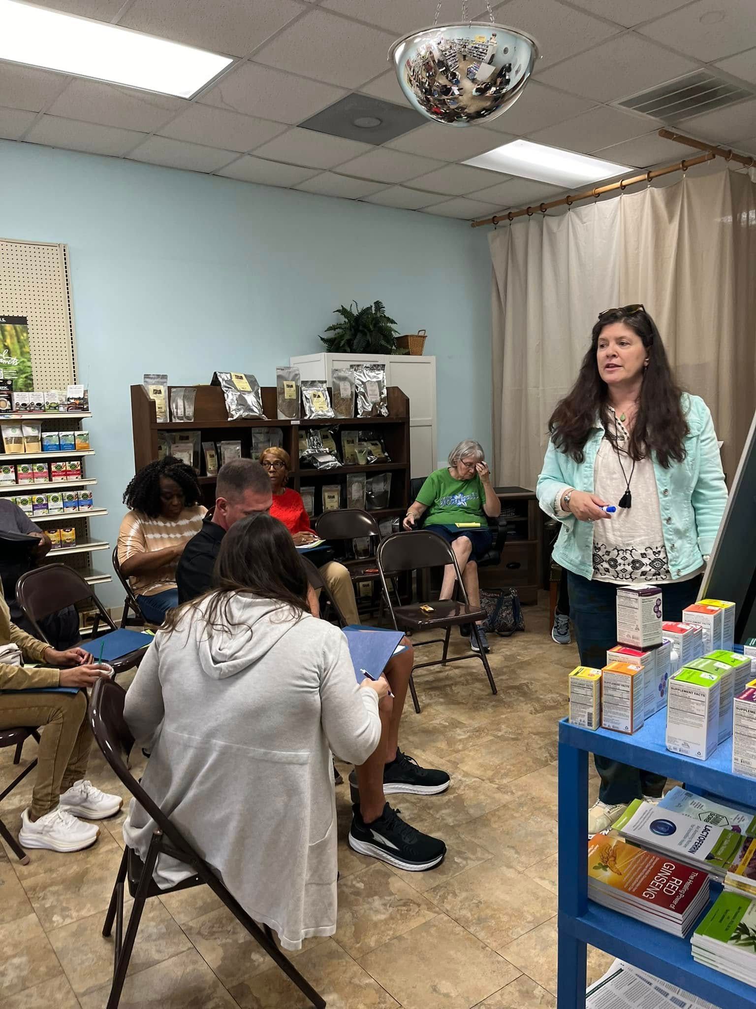A woman is giving a presentation to a group of people in a room.