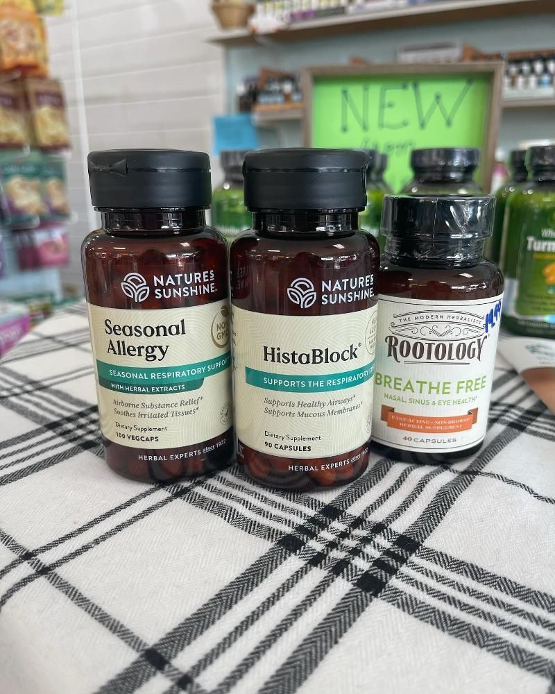 Three bottles of supplements are sitting on a table.