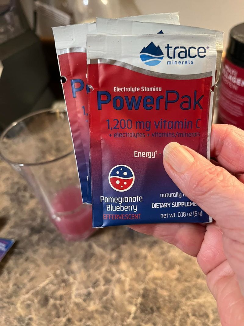A person is holding a packet of powerpak in their hand.