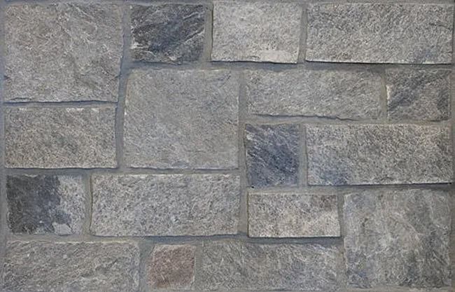Gray stone wall with various sized rectangular blocks.