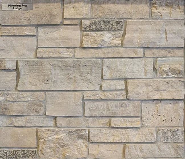 Stone veneer wall with varying shades of beige, tan, and gray, in a stacked rectangular pattern.