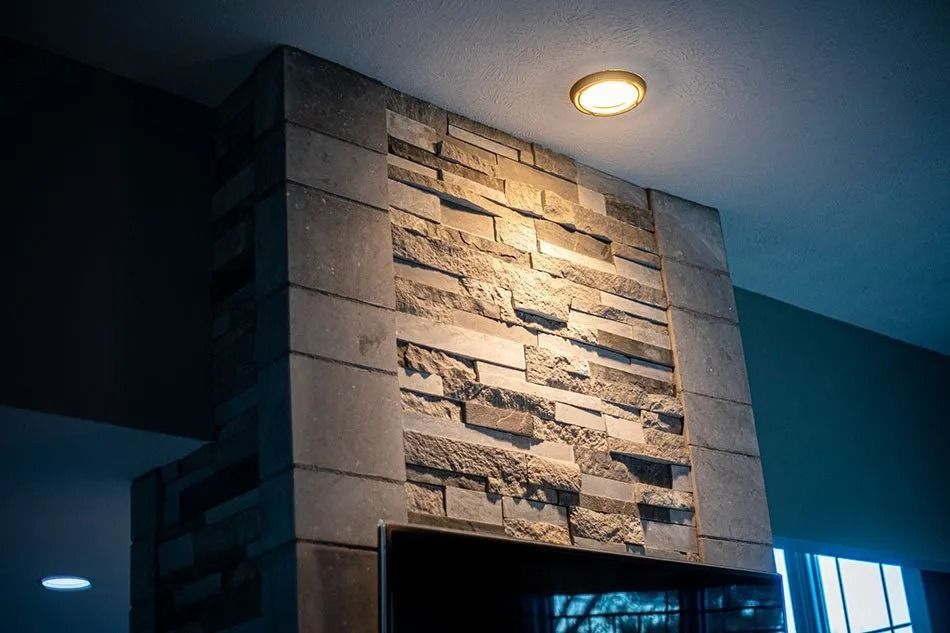 Stone-faced pillar with a recessed area, lit by a warm ceiling light.