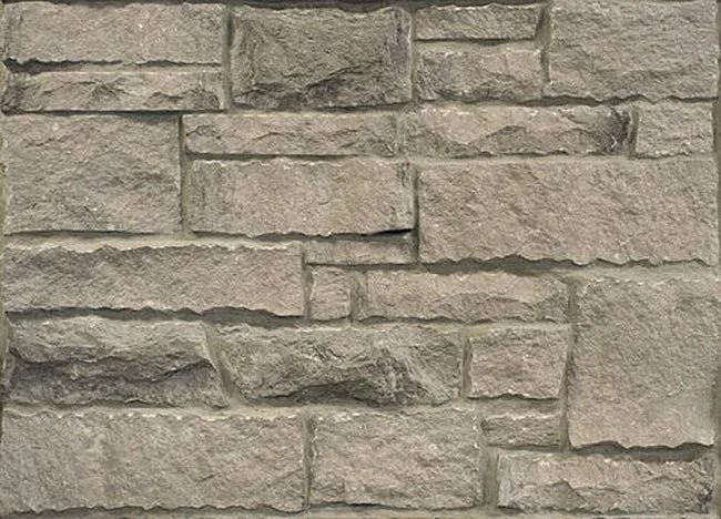 Stone wall composed of rectangular blocks in shades of gray.