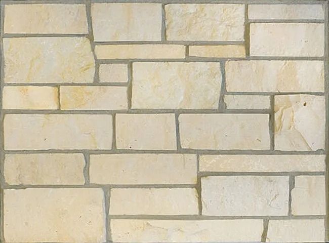 Light tan stone wall with irregular rectangular shapes and gray mortar.