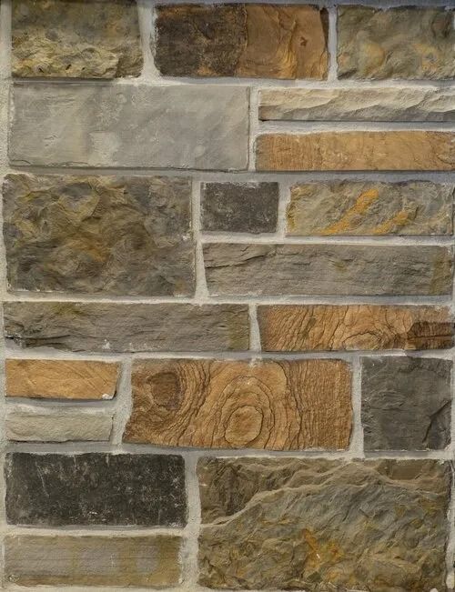 Stone veneer wall, various rectangular stones in shades of brown, gray, and beige with light mortar joints.