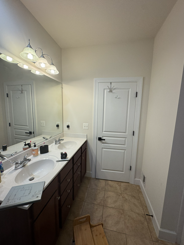 A kitchen with light wood cabinets, appliances, and a central island. A window is in the back.