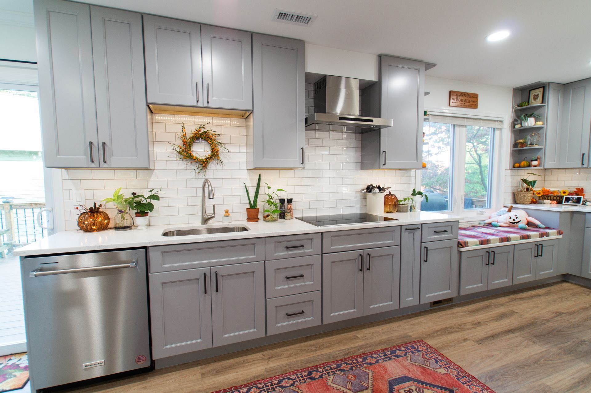 Gray kitchen with cabinets, stainless steel appliances, and white countertops.