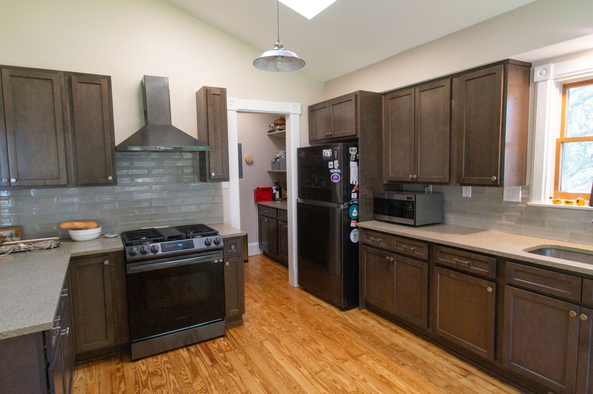 Kitchen with brown cabinets, stainless steel appliances, and wood floors.