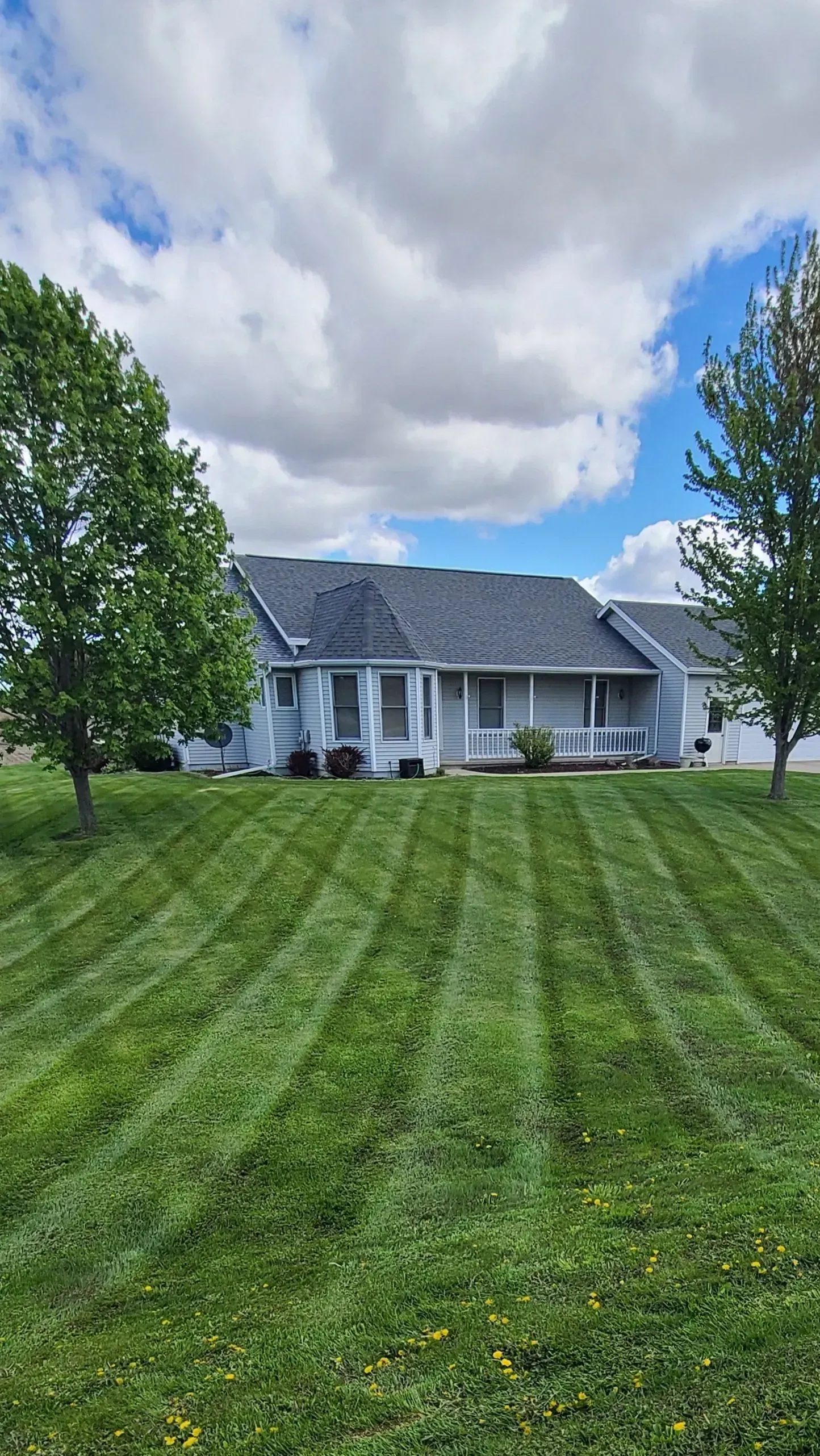 A large white house with a lush green lawn in front of it.