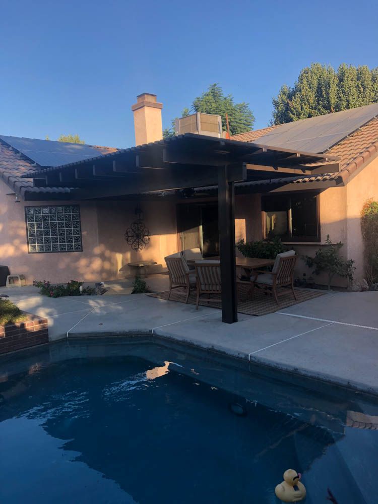 A house with a swimming pool and a pergola over it.