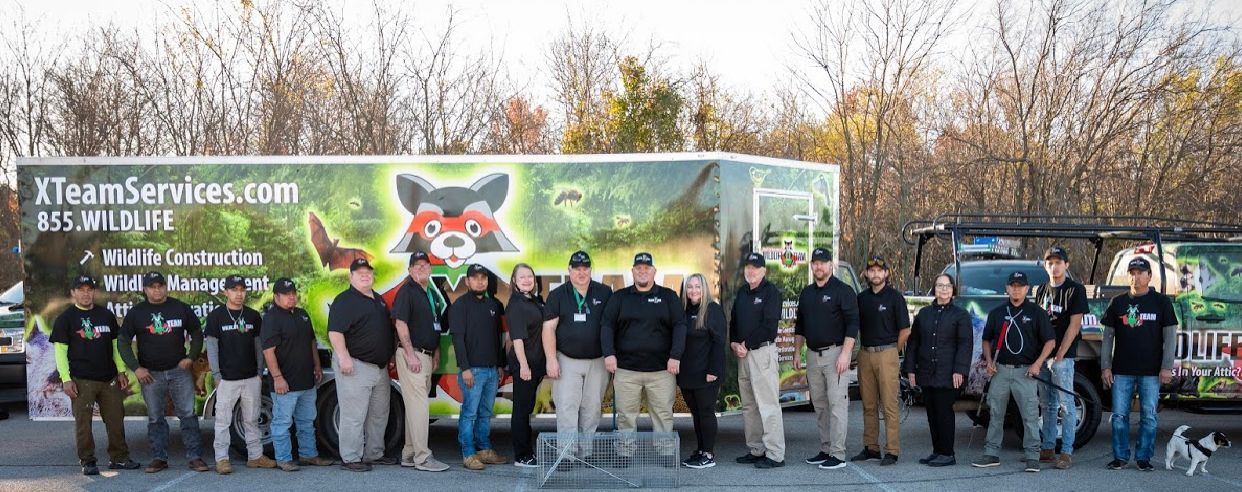 Group of people in front of a branded truck banner, standing outdoors in jackets and casual clothes