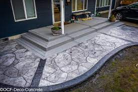 A concrete walkway with steps and a car parked in front of a house