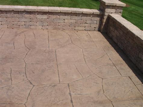 A patio with a brick wall behind it