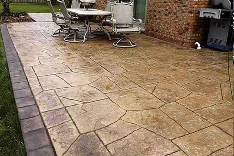 A patio with a table and chairs and a grill