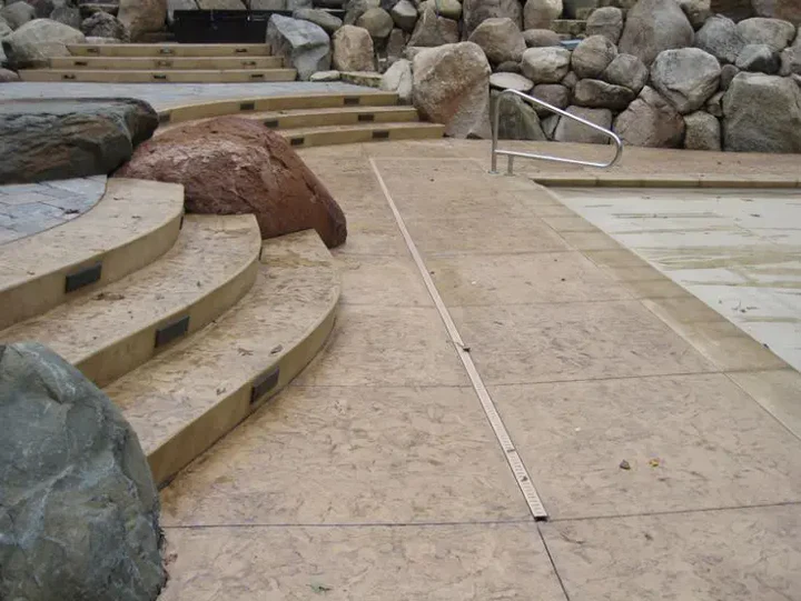 A set of stairs leading to a pool with rocks in the background