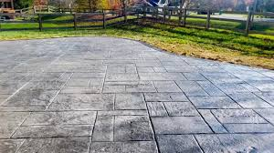 A concrete driveway with a fence in the background