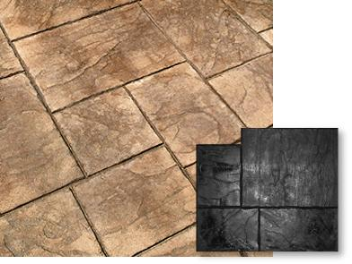 A close up of a concrete floor with a black tile next to it