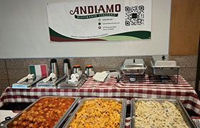 Italian buffet with food trays, warming equipment, and an Andiamo sign.