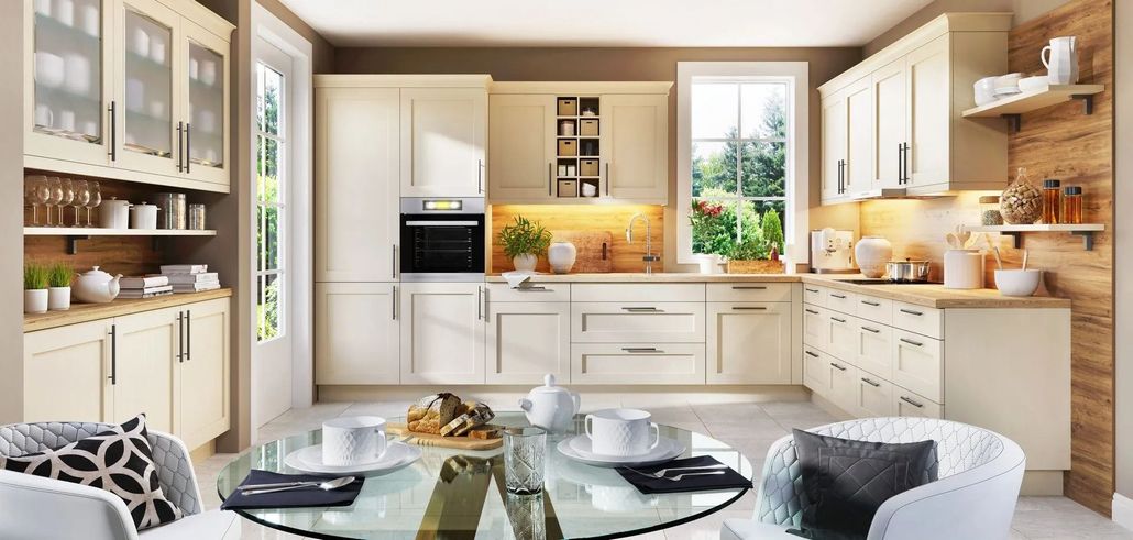 Cream-colored kitchen with a round glass table set for a meal. The window looks out onto greenery.