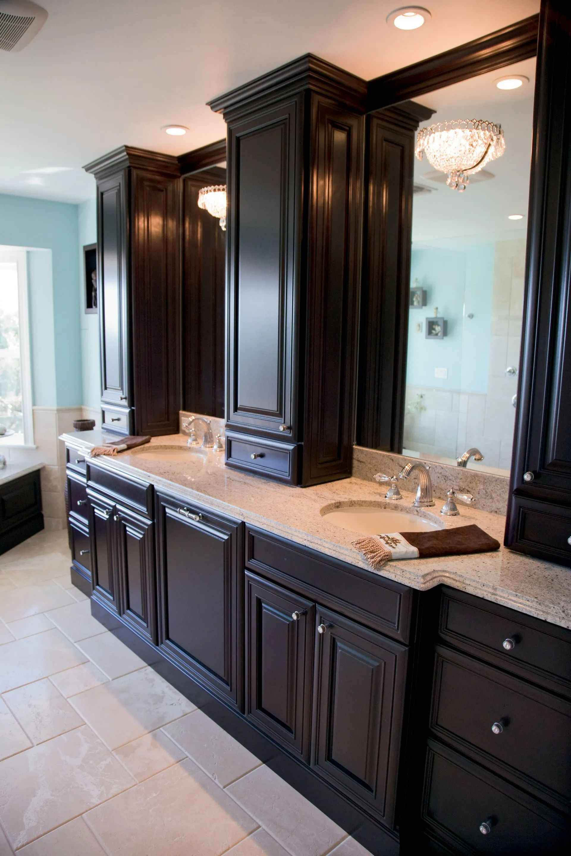 Dark wood bathroom vanity with granite countertop and matching cabinets.