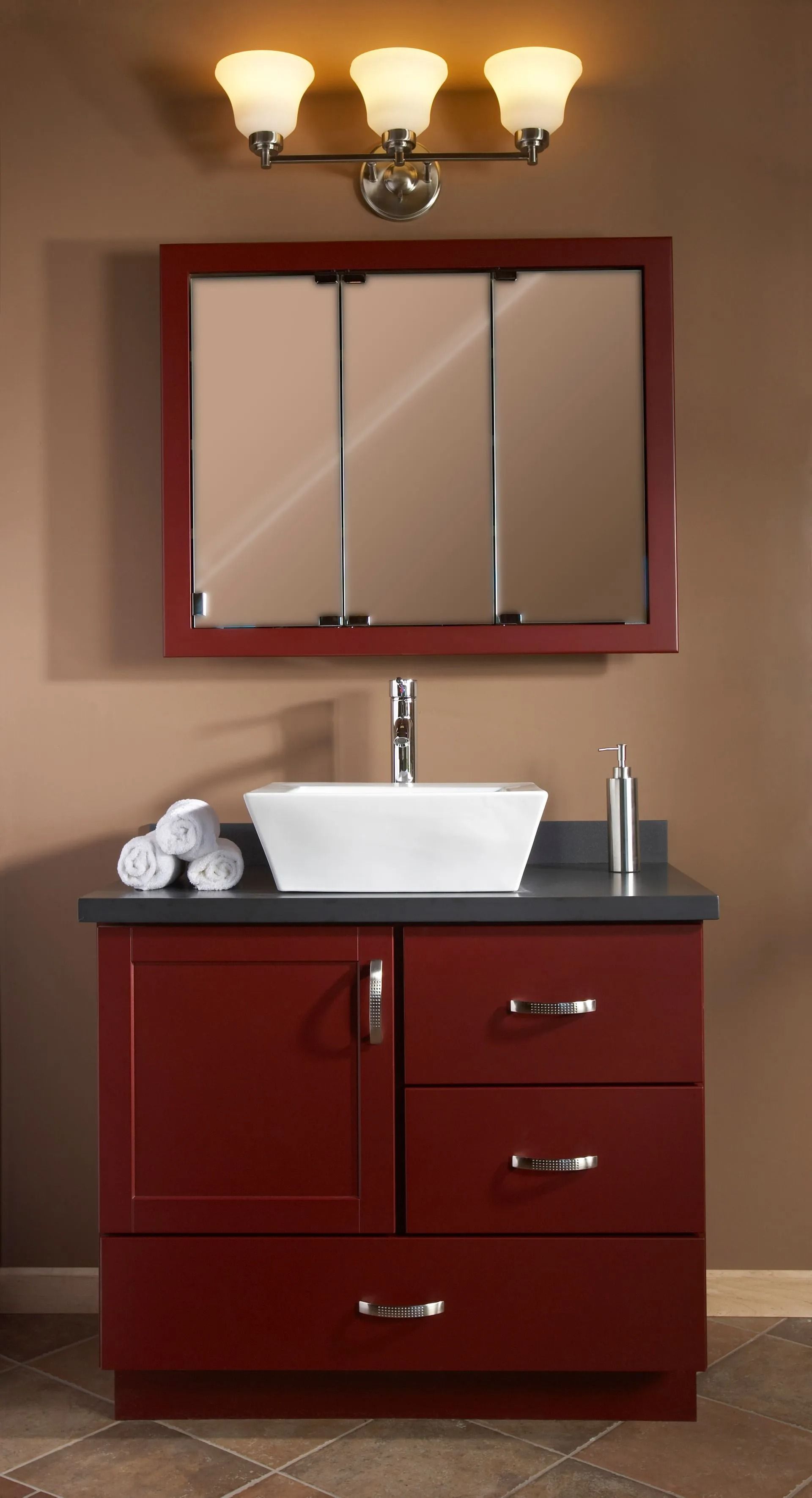 Red vanity with sink, mirror, and overhead lights in a bathroom.