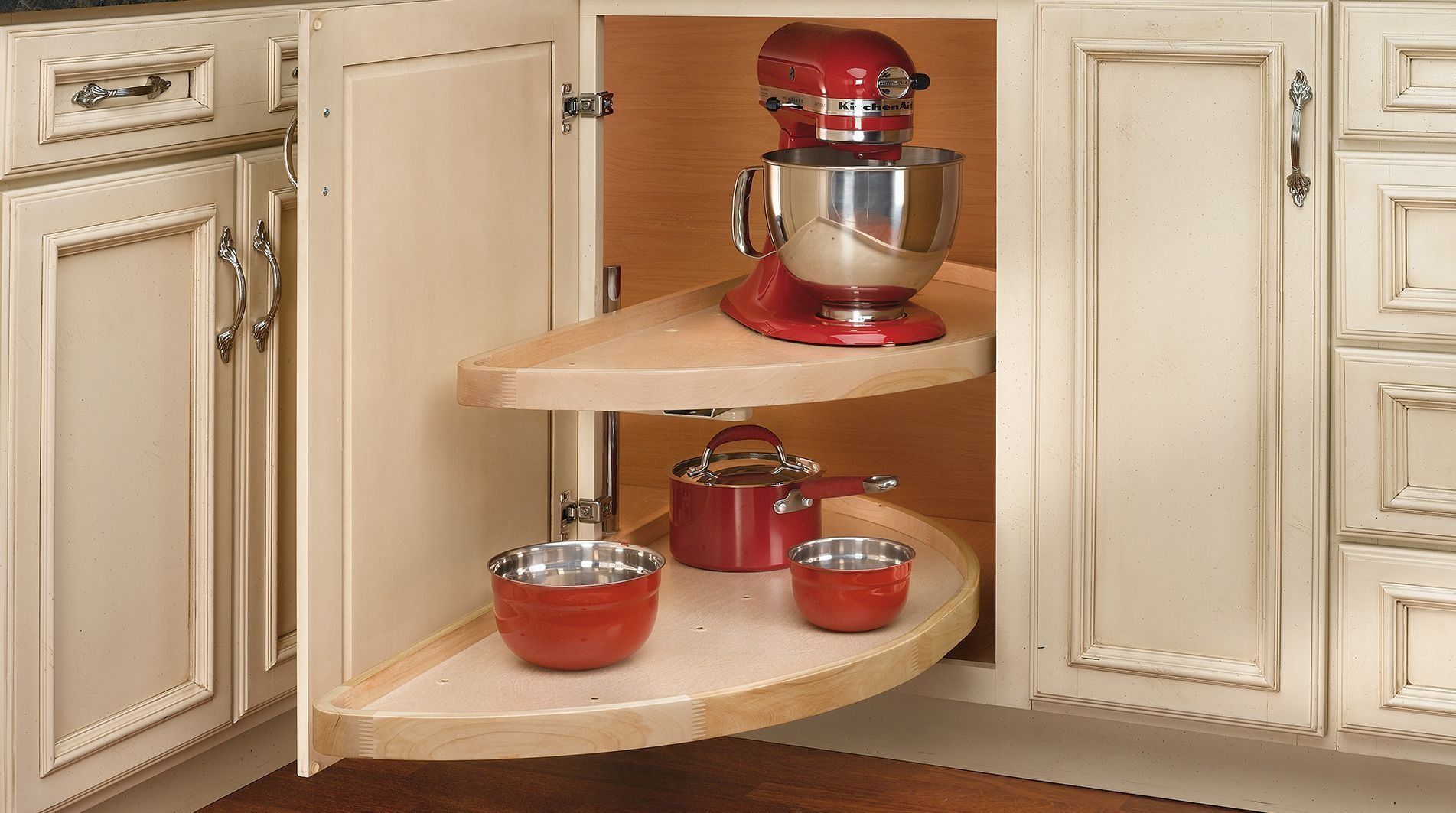 Kitchen cabinet with a lazy susan holding a mixer and bowls.