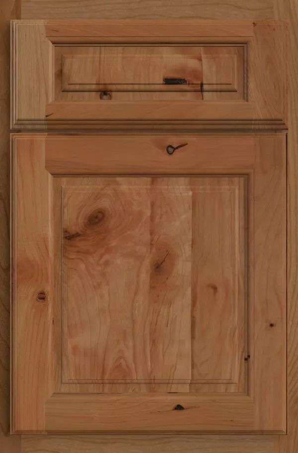 Wooden cabinet door with raised panel and upper detail, showing wood grain.