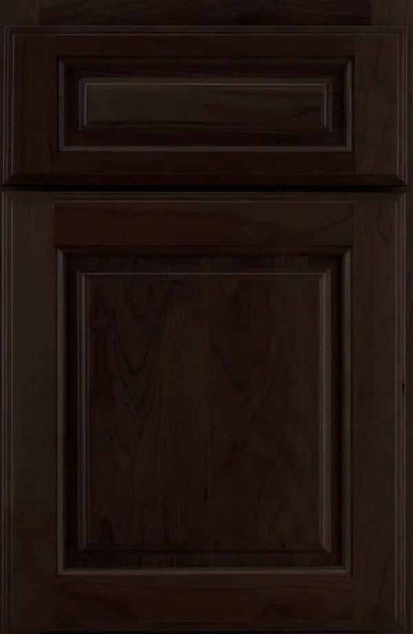 Dark brown cabinet door with raised panel and recessed upper panel.