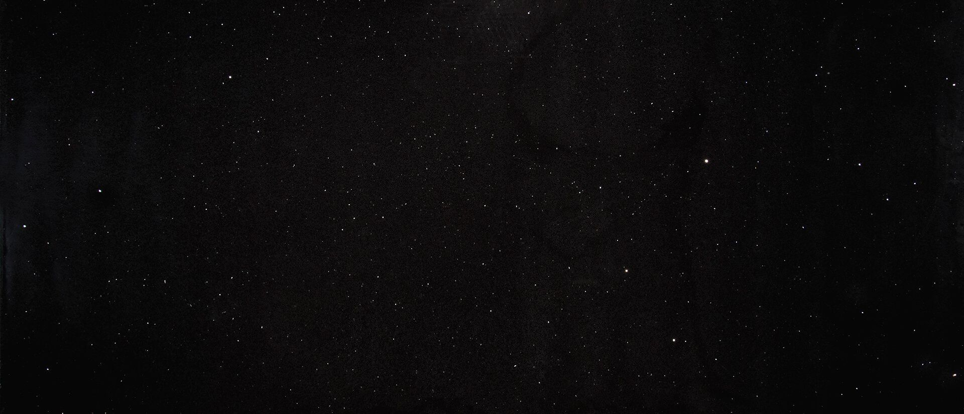 Dark starry night sky with white and yellow points of light.