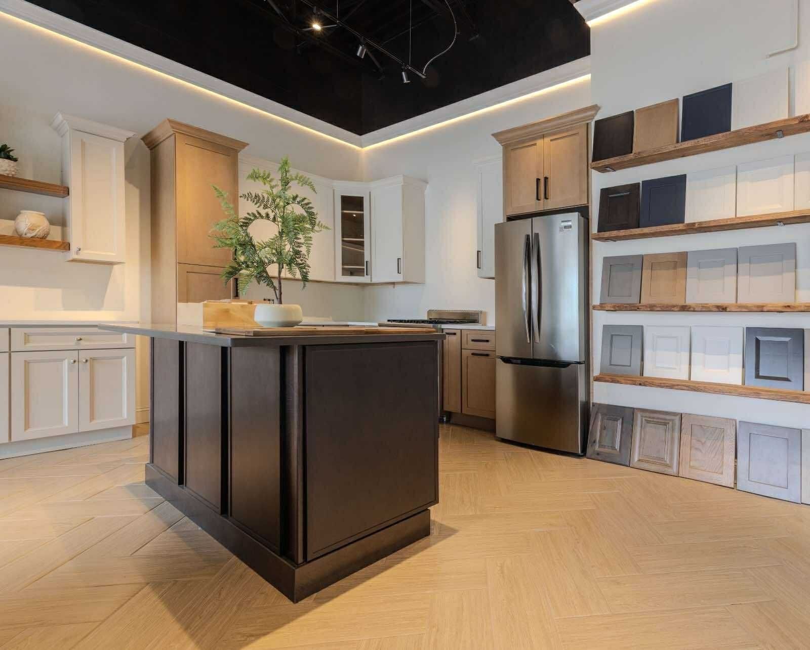 Kitchen display with cabinets, island, and stainless steel refrigerator.