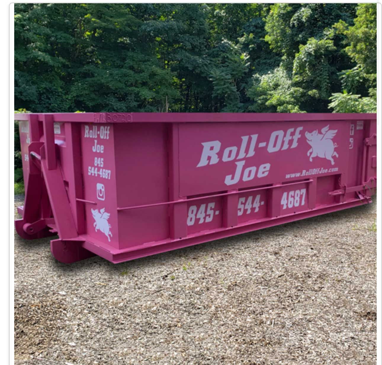 Pink Roll-Off Joe dumpster on gravel, in front of trees. Phone number: 845-544-4687.