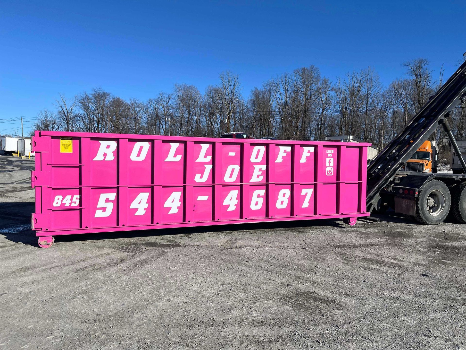 Bright pink roll-off dumpster with white lettering 