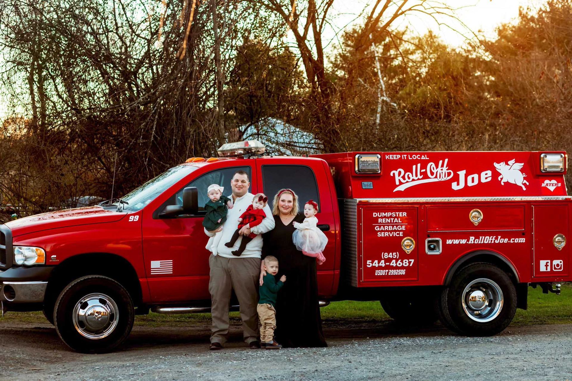 Family of four standing with a red 