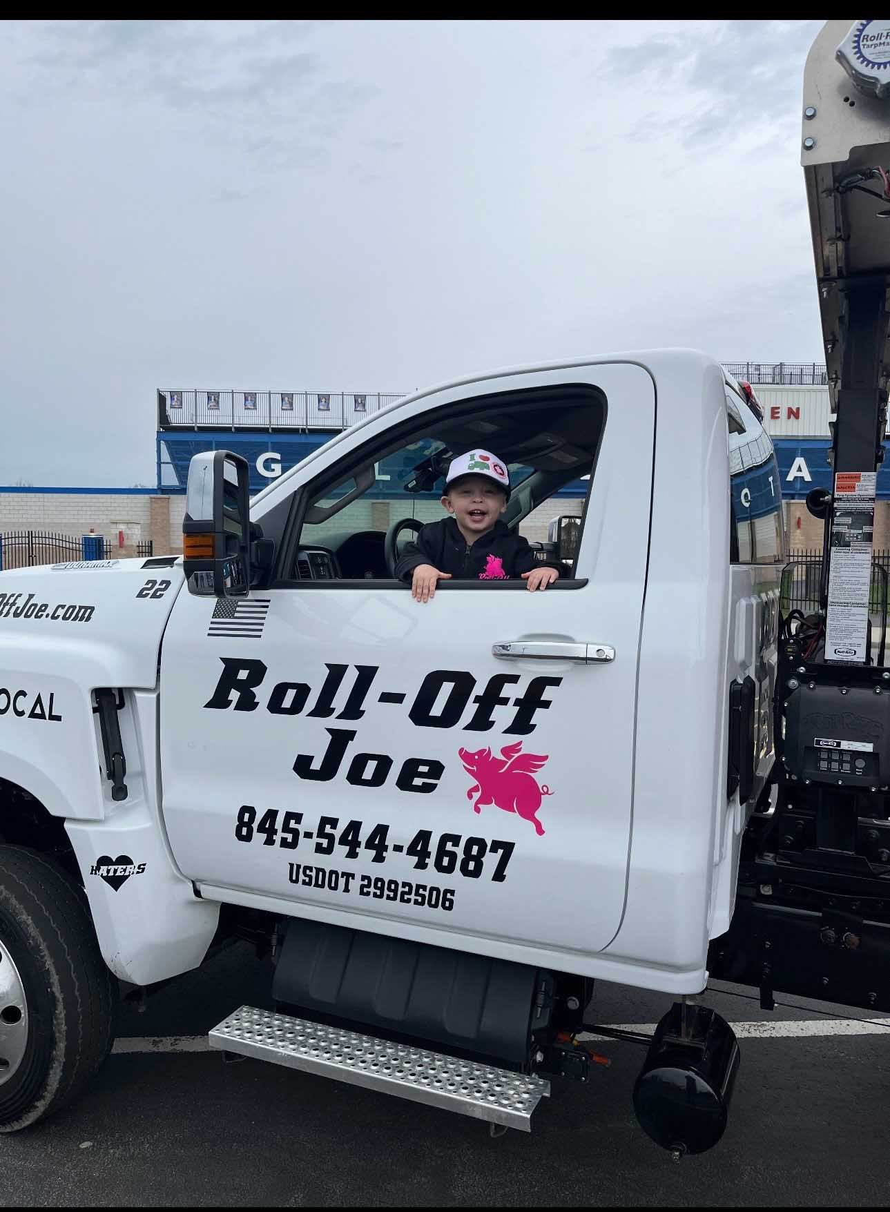 Child smiling in the driver's seat of a white 