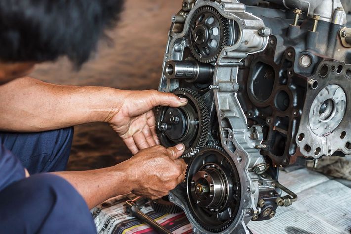 A man is working on a car engine in a garage.