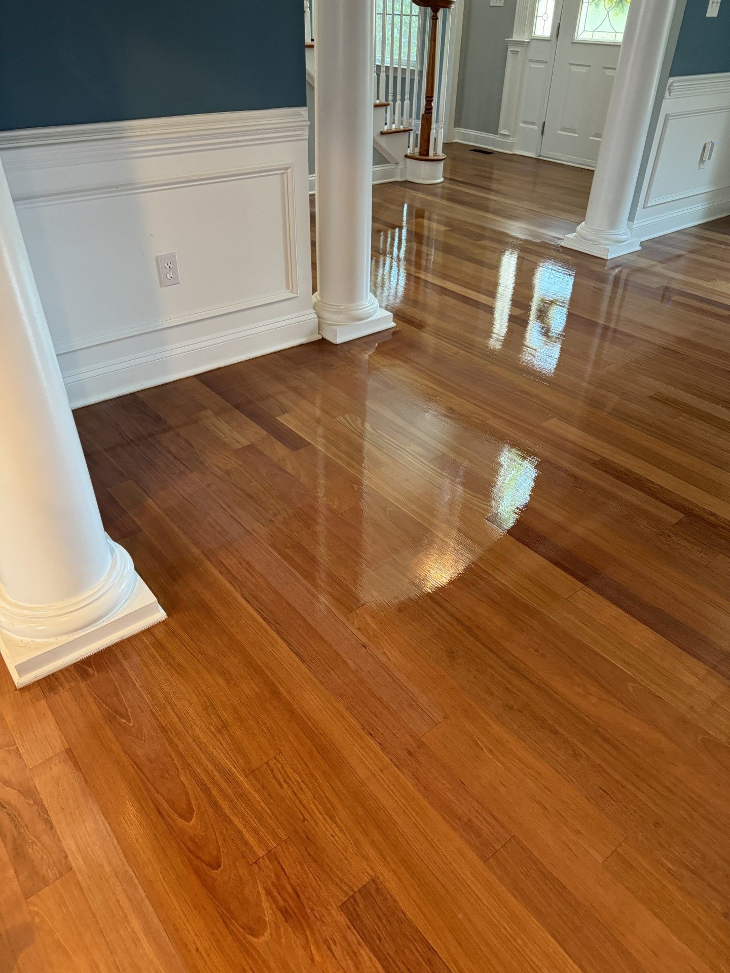 A living room with hardwood floors and white columns.