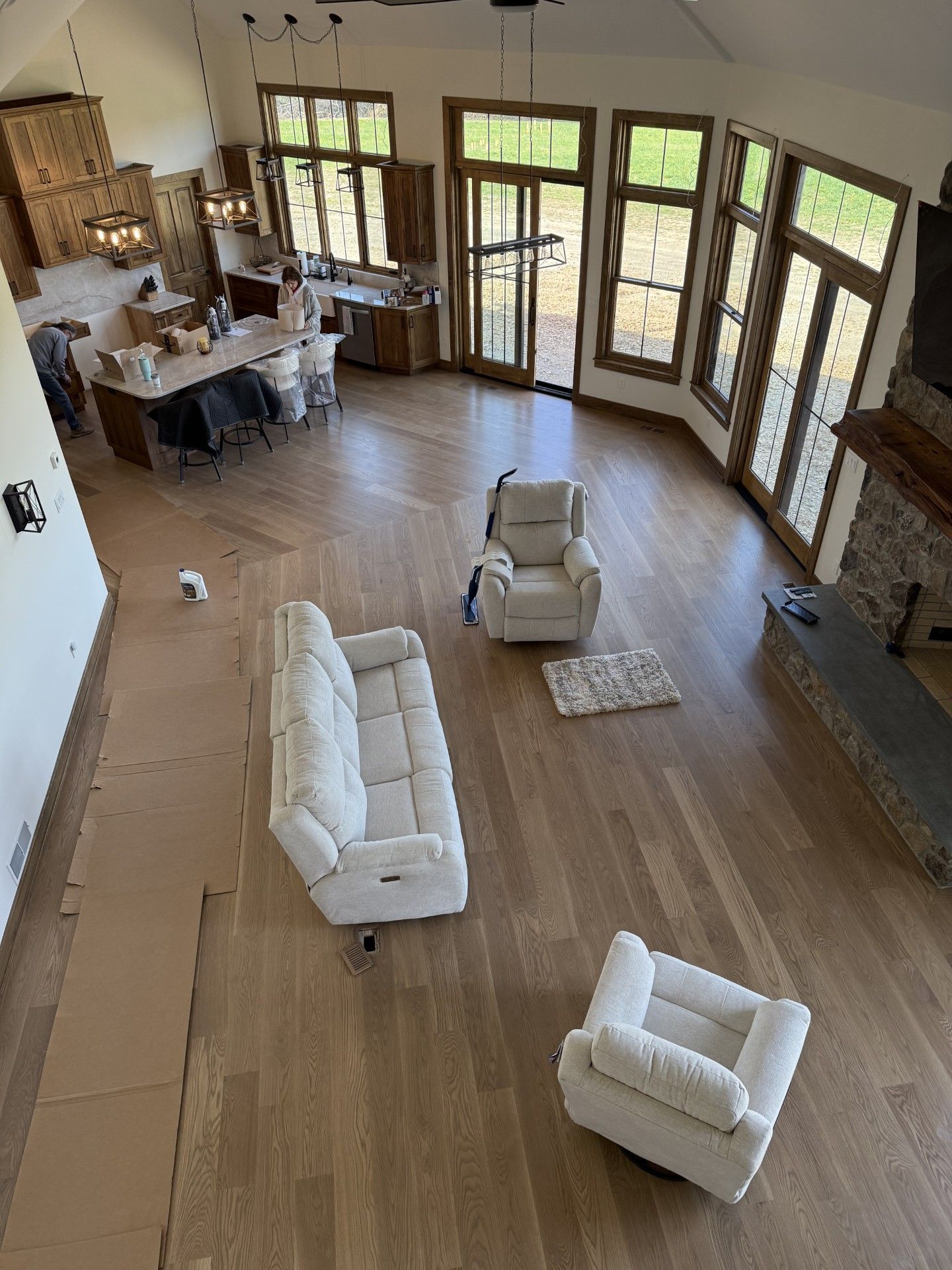 An aerial view of a living room with a couch, chairs, and a fireplace.