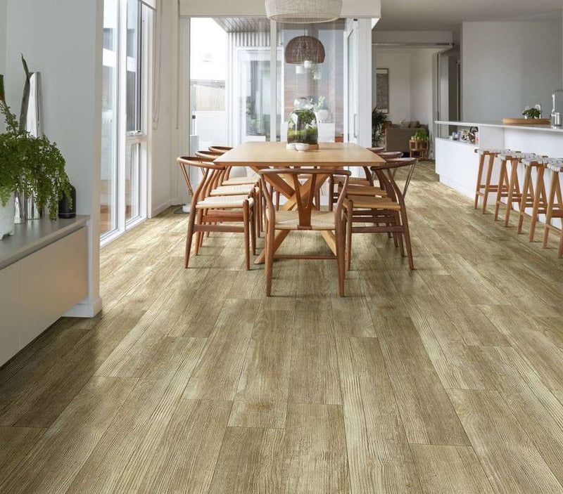 A dining room with a wooden table and chairs and a hardwood floor.