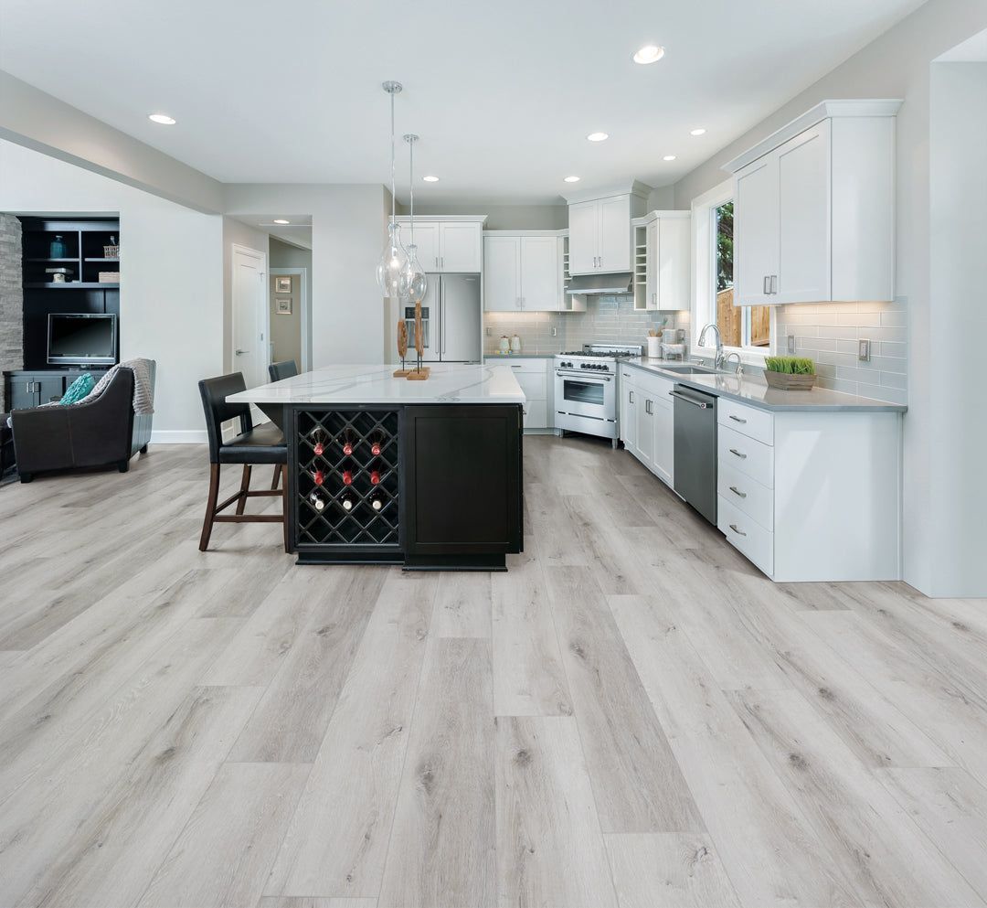 A kitchen with hardwood floors and white cabinets