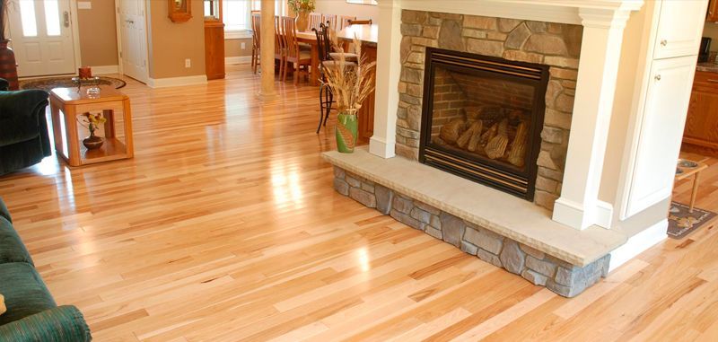 A living room with hardwood floors and a fireplace.