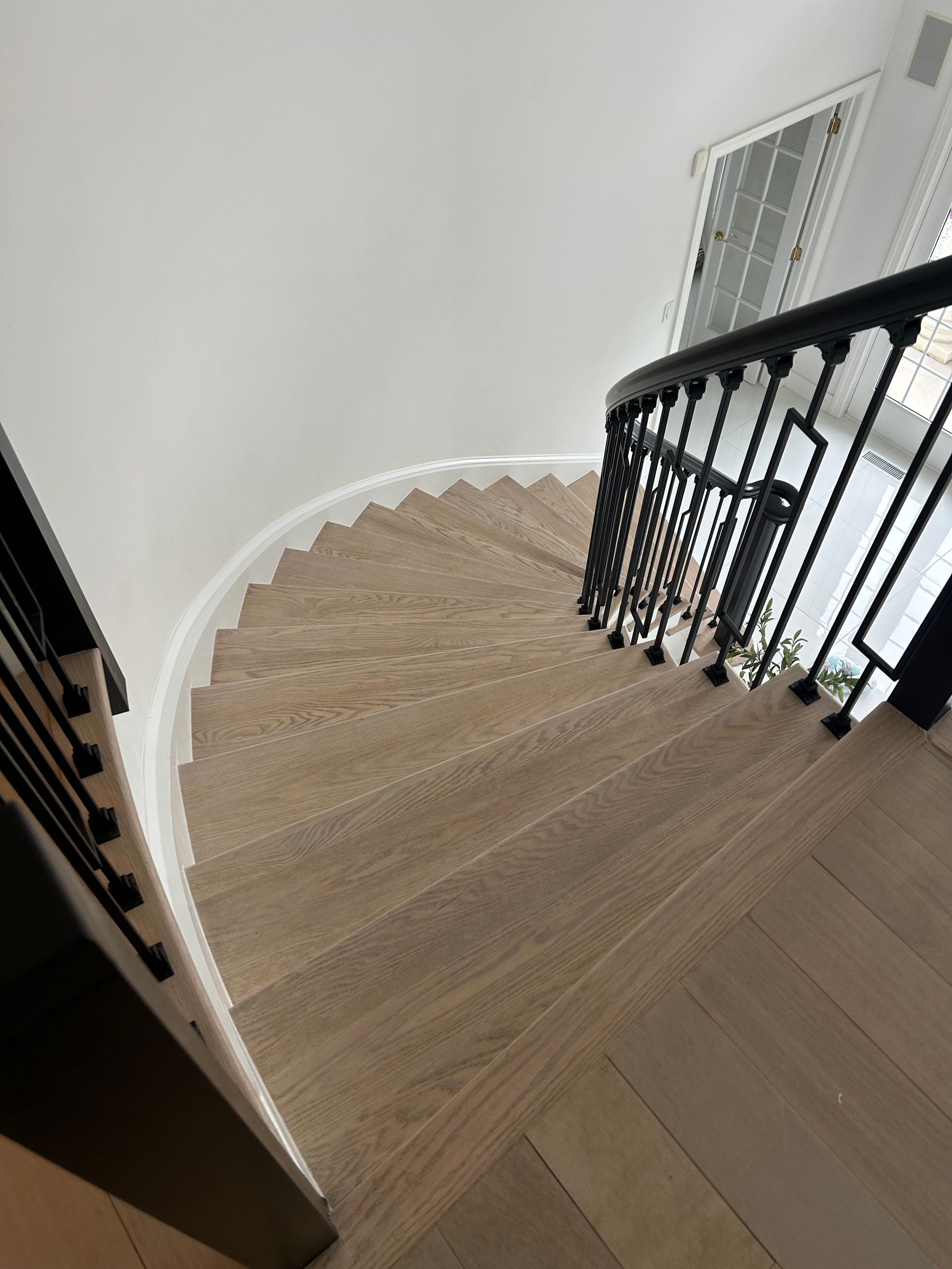 A wooden staircase with a black railing in a house