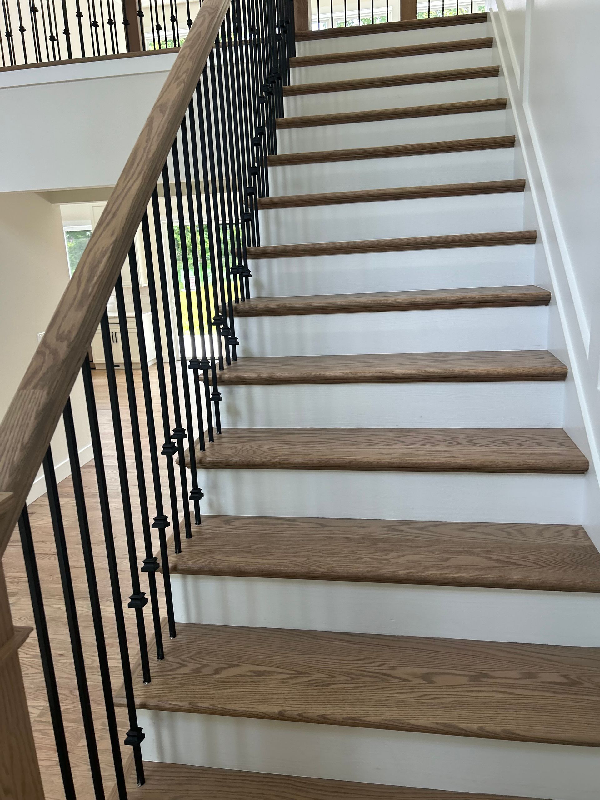 A staircase with wooden steps and a wrought iron railing.