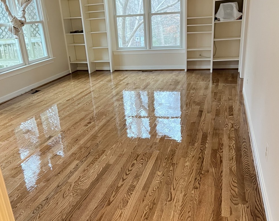 A living room with hardwood floors and white shelves.