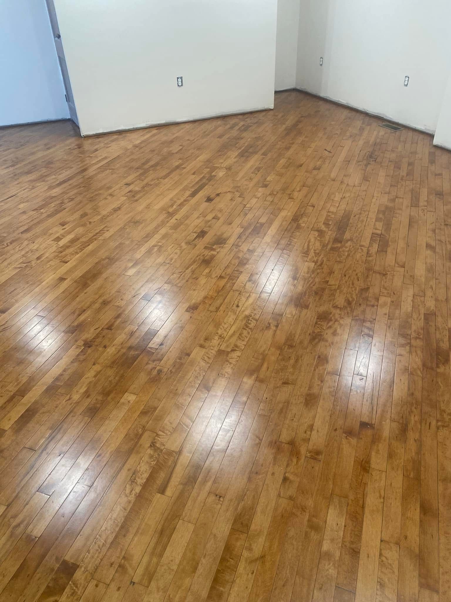 A room with a wooden floor and white walls.