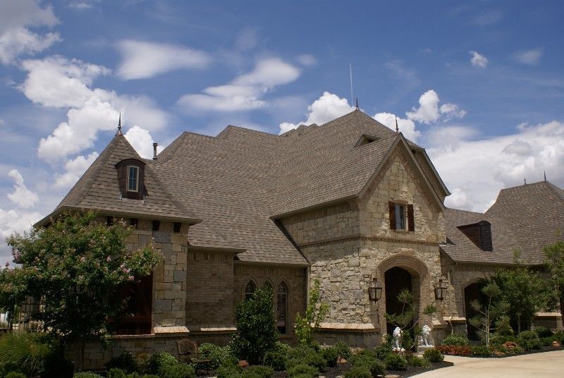 A large stone house with a gray roof