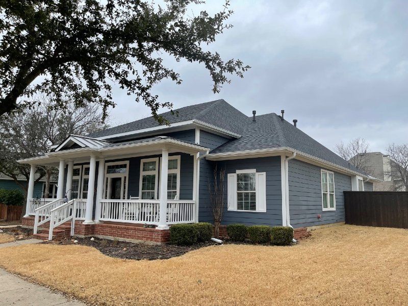 A blue house with a white porch and a gray roof