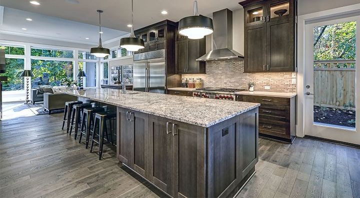 A kitchen with a large island and granite counter tops