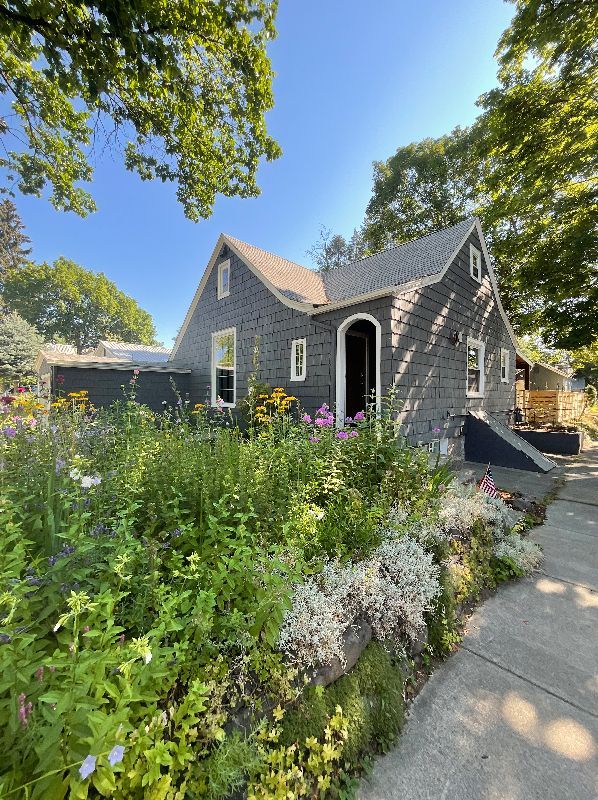 A house with a lot of flowers in front of it